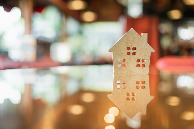 Hard papier huis op de tafel, een symbool voor de bouw