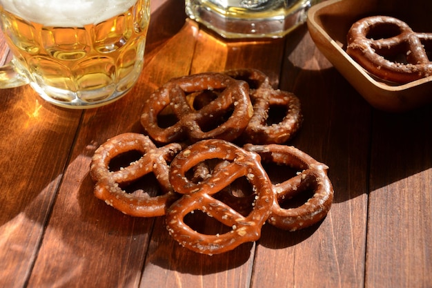 Hard pretzels or salted pretzels snack for party on rustic wooden table with glass of beer