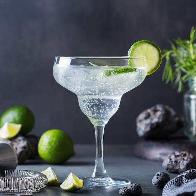 Hard seltzer cocktail with lime, rosemary and ice on a table. Summer refreshing beverage, drink