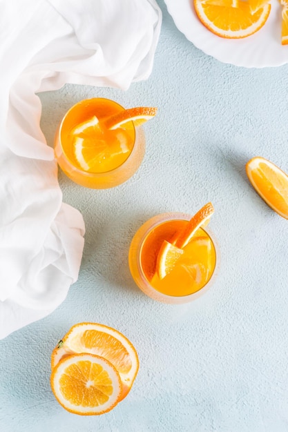 사진 테이블에 있는 안경에 있는 단단한 셀처 상쾌한 오렌지 칵테일 집에서 만든 음료 위쪽 및 수직 보기