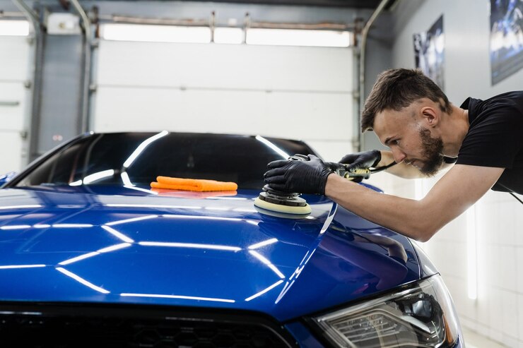 Hard wax car polishing with orbital polisher for remove scratches closeup Working process in detailing auto service