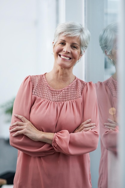 Hard work pays off believe me Portrait of a cheerful mature businesswoman posing with her arms folded in her office at work