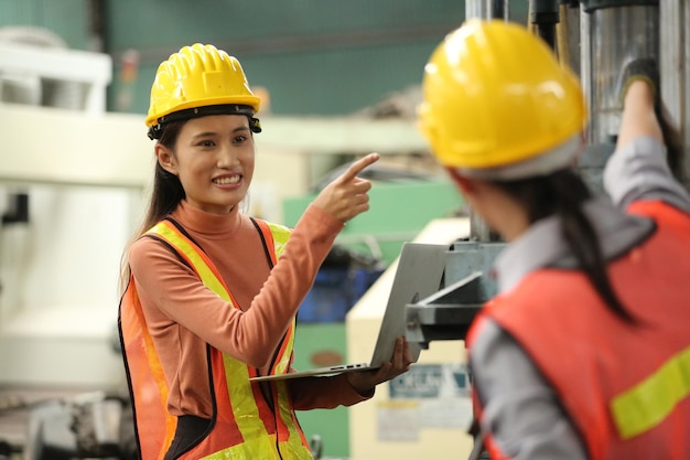 Hard-working engineer holding digital tablet in hands while working in manufacturing plant, profile view