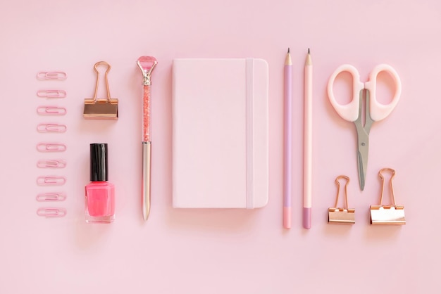 Quaderno con copertina rigida e accessori rosa scuola girly su rosa pastello vista dall'alto mockup