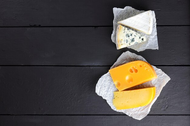 Foto harde gele kaas camembert en blauwe kaas op zwarte planken zwitserse kaas en dorblu