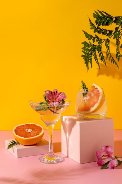 Harde seltzercocktails met bessenaroma's gegarneerd met alstroemeriabloem. verfrissend kleurrijk zomerdrankje op gele achtergrond met schaduwvaren.