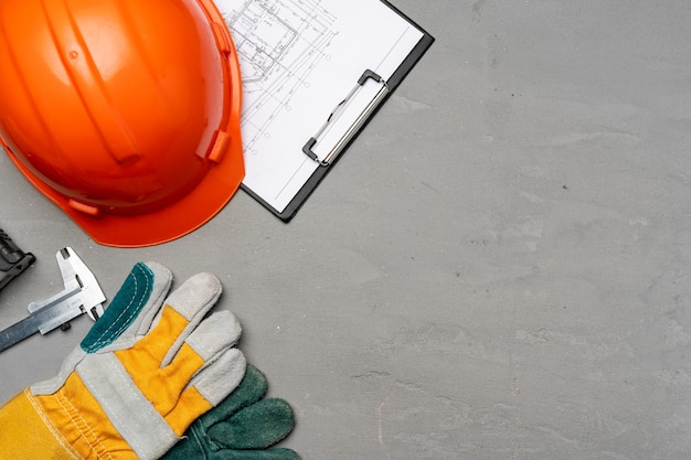 hardhat, gloves and blueprints of a builder top view