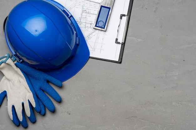 Hardhat, gloves and blueprints of a builder top view