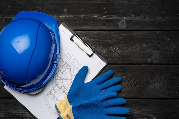 Photo hardhat gloves and blueprints of a builder top view