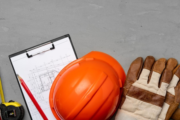 Hardhat, gloves and blueprints of a builder top view