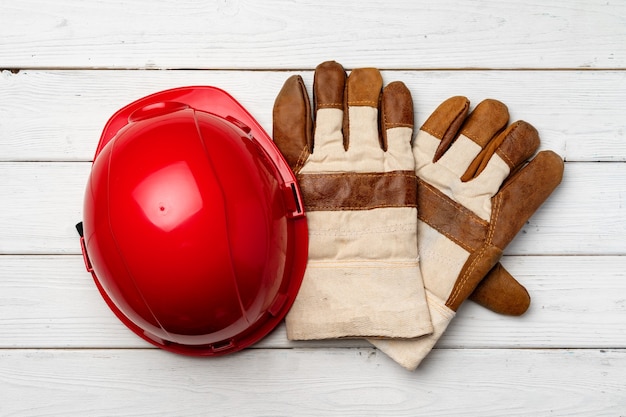 木製の表面上面図の建設作業員のヘルメットと手袋