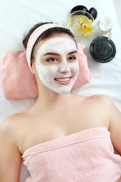 Hardware cosmetology closeup picture of lovely young woman with\
cream mask in a beauty parlour