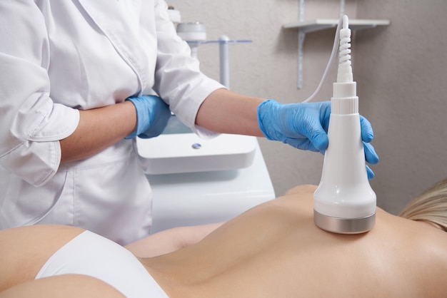 Hardware cosmetology young woman getting beauty treatment in spa salon