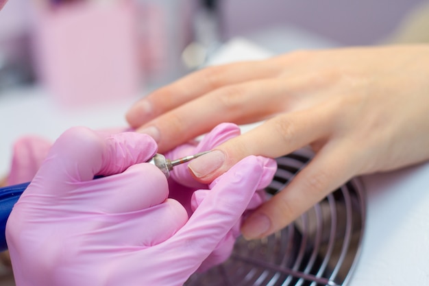 Manicure hardware con macchina elettrica. procedura per la preparazione delle unghie prima di applicare lo smalto.