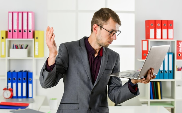 Hardwerkende behendige zakelijke zakenman die aantekeningen maakt man draagt kantoorpak mannelijke makelaar heeft een harde werkdag online cursussen tutor leider van het advocatenkantoor zelfverzekerde advocaat die met de computer werkt