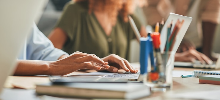 Foto hardwerkende persoon die typt terwijl hij op de laptop werkt