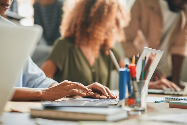 Foto hardwerkende persoon die typt terwijl hij op de laptop werkt