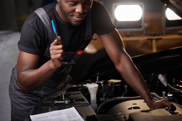 Hardwerkende werknemer in uniform werkt in de autosalon