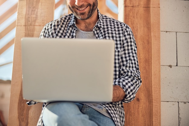 Hardworking brunette man using his laptop outside