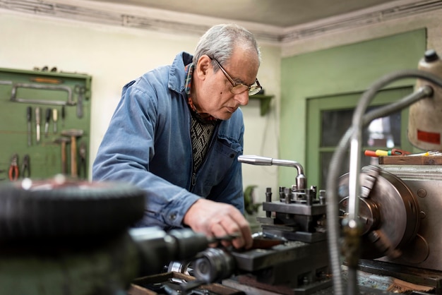 Foto uomo laborioso che fa il suo lavoro in un'officina industriale