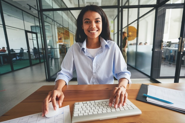 Hardworking young lady posing at her minimalistic workplace