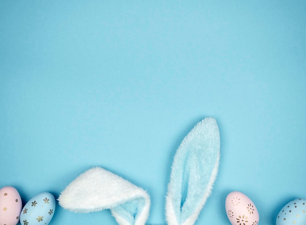 Photo hare ears with easter eggs on a blue background easter concept space for text