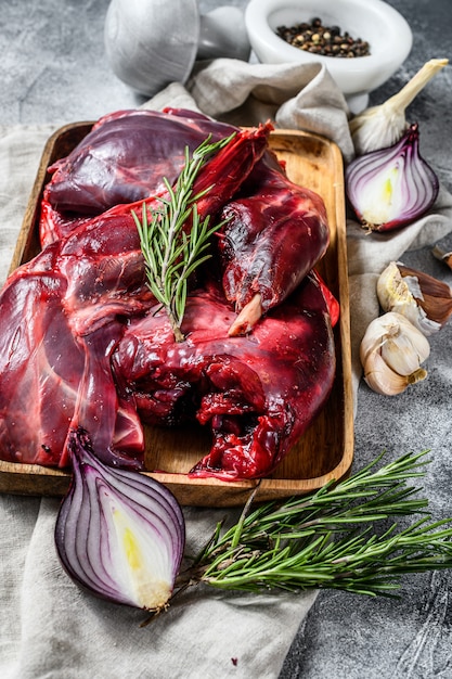 Hare meat. Raw fresh  wild hare on a wooden table with vegetables and spices. Top view. Organic meat