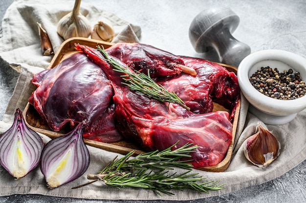 Hare meat. Raw fresh  wild hare on a wooden table with vegetables and spices. Top view. Organic meat