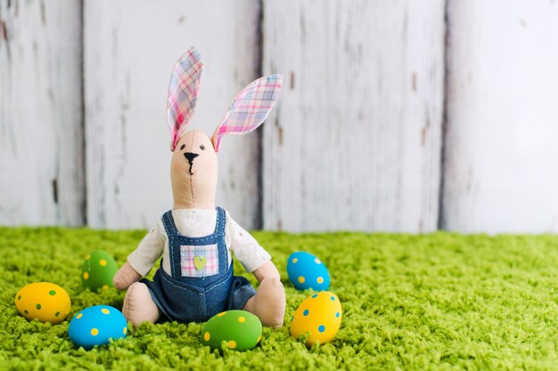 Hare sitting on the grass with Easter eggs