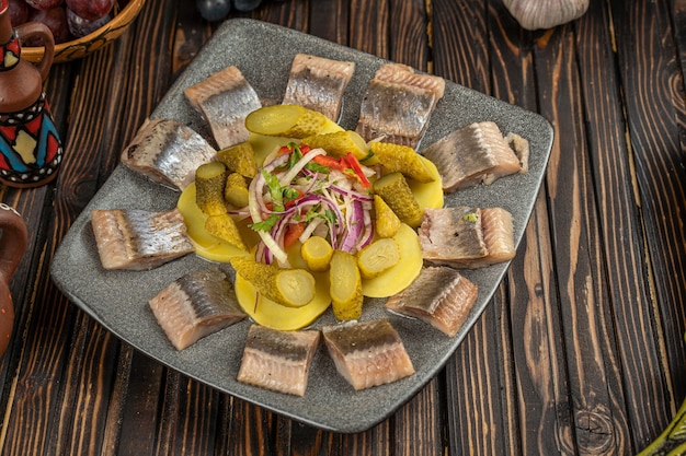 Haring, ingelegde komkommer, bieten, aardappel en eiersalade op witte plaat, bovenaanzicht. Hoge kwaliteit foto