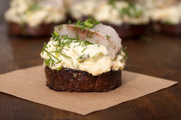 Haringfilet op geroosterd roggebrood en salade met eieren groene uien dille en mayonaise