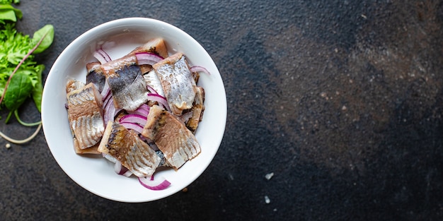 Haringvis met uiensalade op een kom