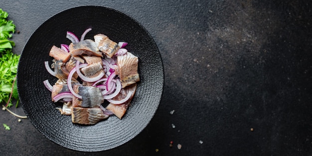 Haringvis met uiensalade op een kom