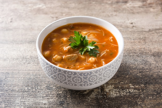 Harira soup in bowl on wooden table typical moroccan food