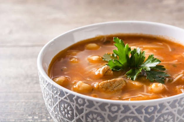 Harira soup in bowl on wooden table Typical Moroccan