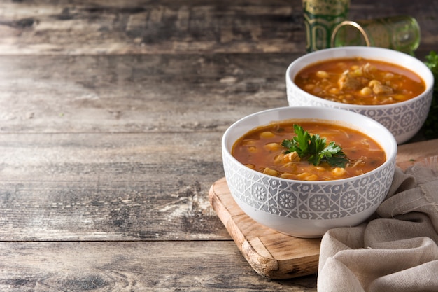 Harira soup in bowl on wooden table