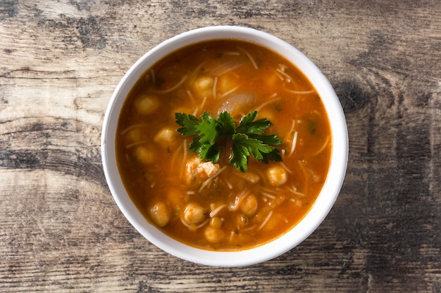 Harira soup in bowl on wooden table