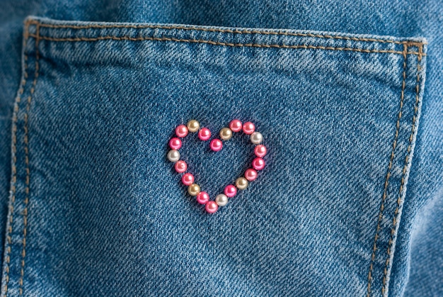 Hart frame gemaakt van naalden op denim jeans achtergrond