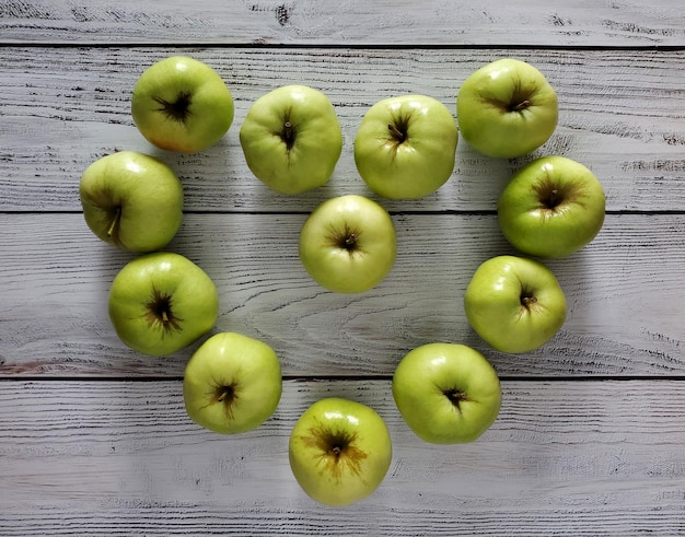 Hart gemaakt van groene appels op lichte houten ondergrond, bovenaanzicht, plat gelegd.
