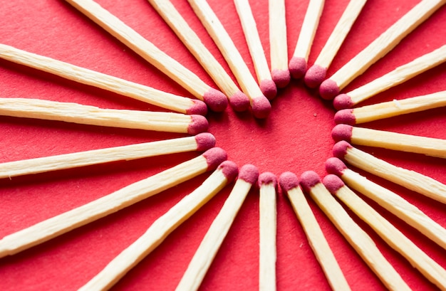 hart gemaakt van lucifers op rood oppervlak. liefde. Valentijnsdag briefkaart. Liefdeconcept voor moederdag met ruimte voor tekst