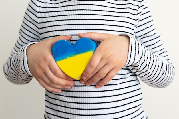 Hart geschilderd in de kleuren van de vlag van Oekraïne in kinderhanden