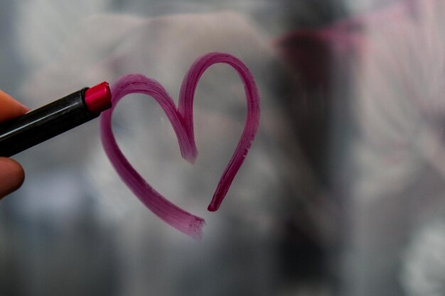 Hart geschilderd op glas met lippenstift Valentijnsdag liefde en romantiek hart getekend door een lippen