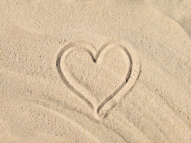 Hart getekend in het zand met het woord liefde erop