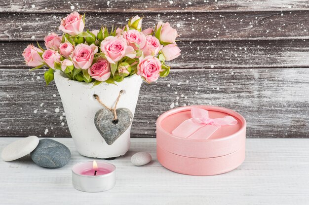 Hart, roze rozen in betonnen pot met kaarsen