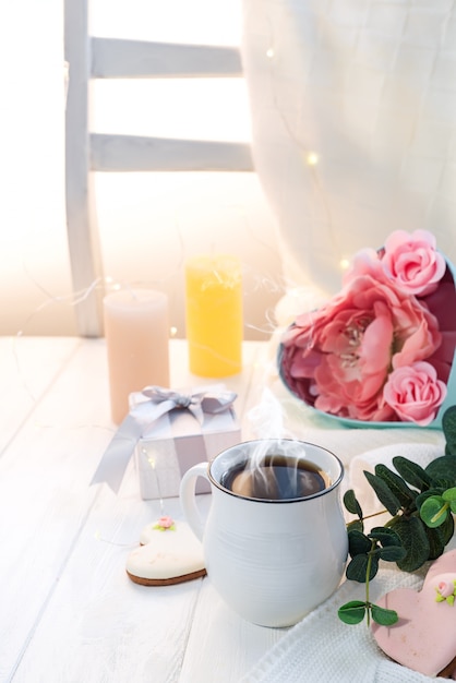 Hartkoekjes met kop van koffie op houten achtergrond met plaid