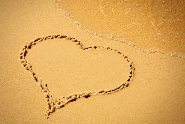 Foto harttekening in het zandstrand.