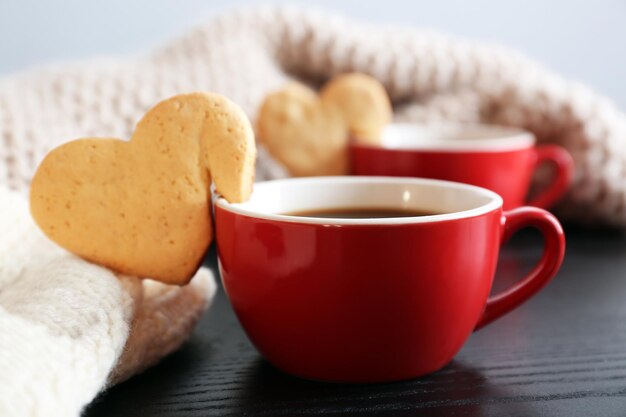 Hartvorm cookie op kopje koffie op houten tafel close-up