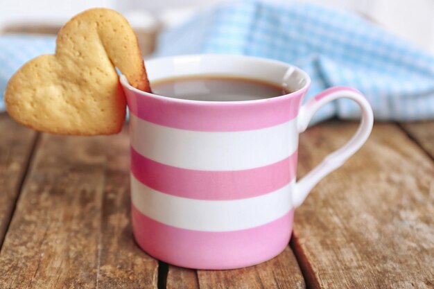 Hartvorm cookie op kopje koffie op houten tafel close-up