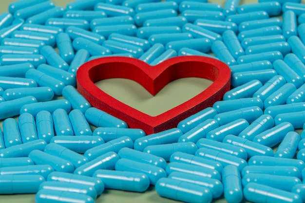 Foto hartvorm en blauwe capsules belangrijkheid van medicatiebehandeling