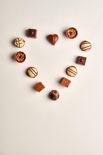 Hartvorm gemaakt met verschillende soorten chocoladetruffels boven een witte tafel